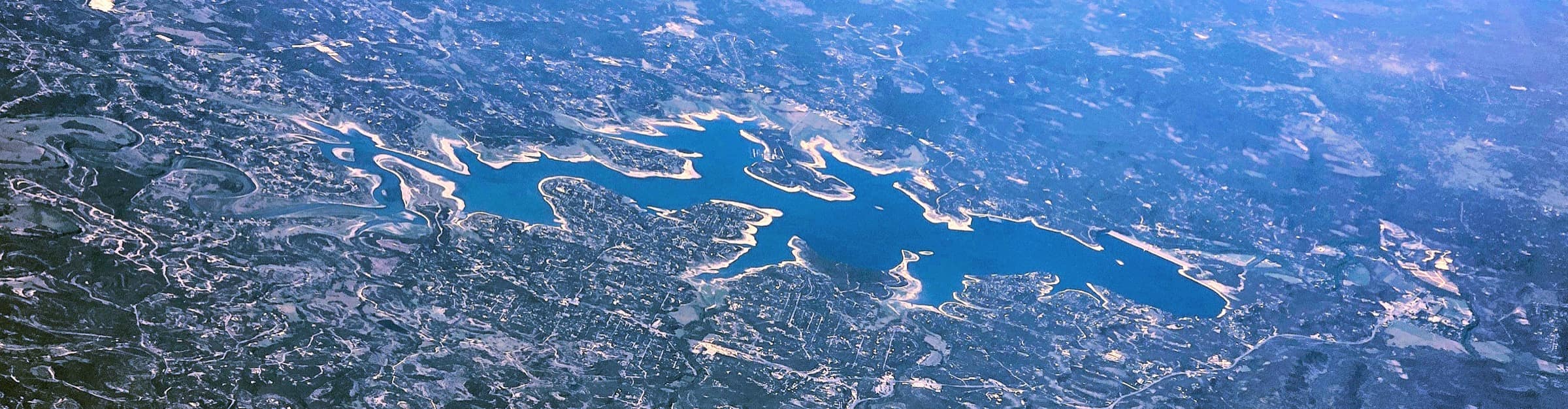 The whole of Canyon Lake from the air, Canyon Dam at the right-hand end, the Hill Country all round