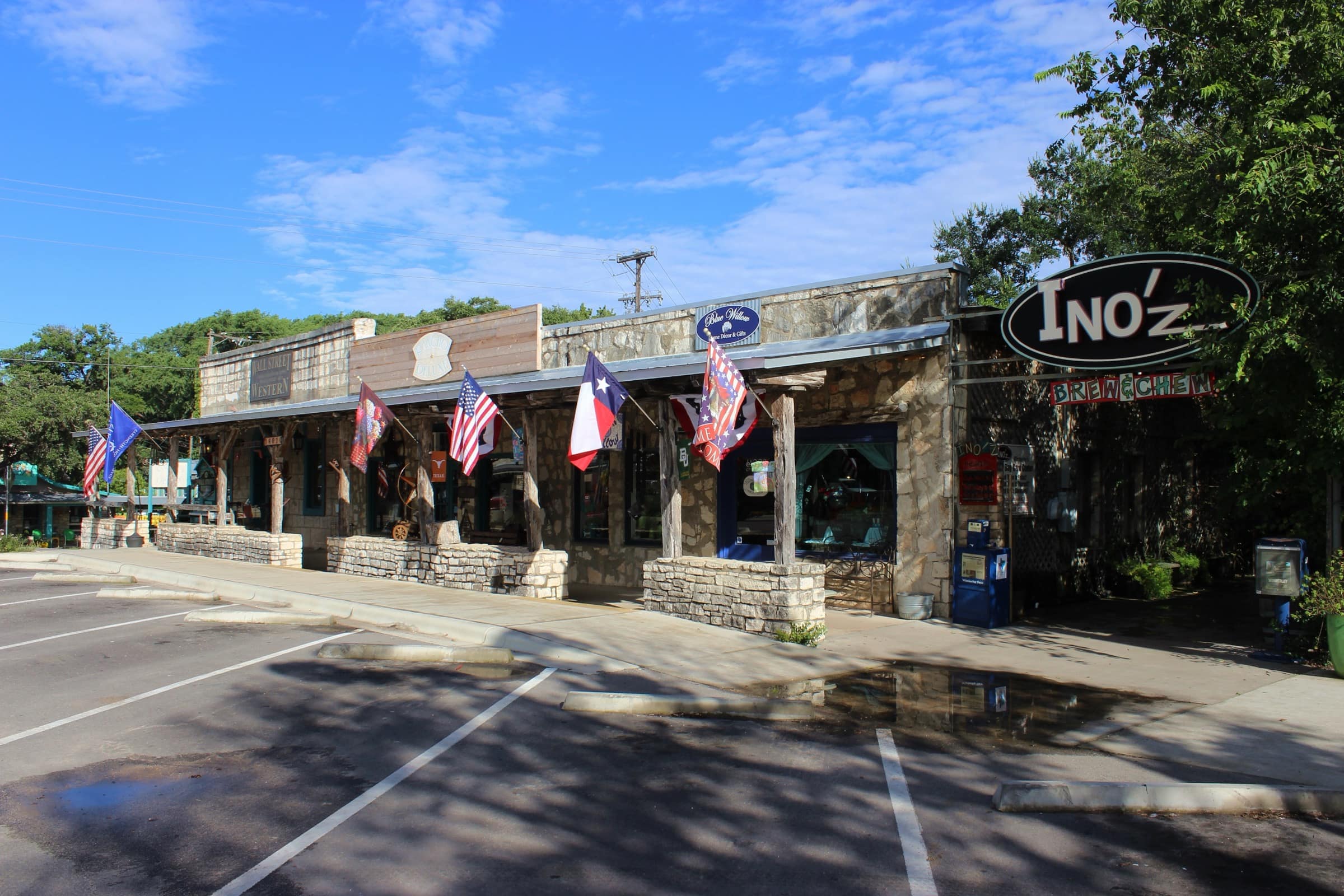Stone-fronted shops on the Wimberley Square hung with Texas and US flags